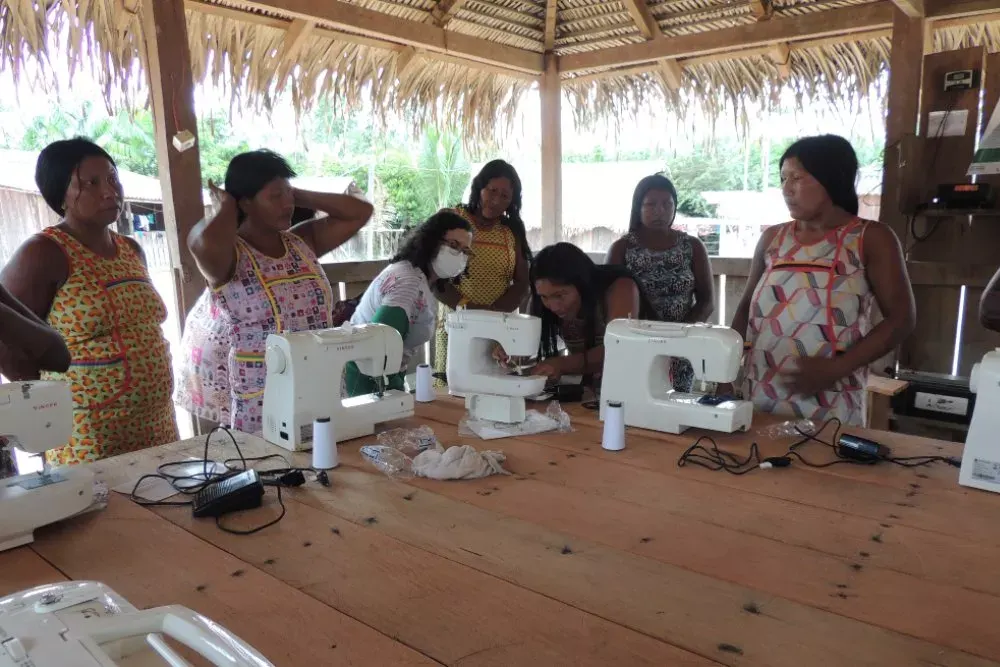 Artisans working at sewing machines in a covered workshop