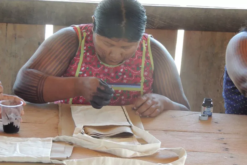 An artisan finishes a piece of fabric