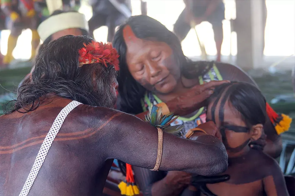 Mulheres e crianças reunidas durante a preparação de um ritual